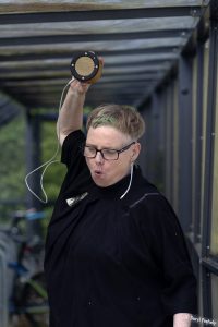 Iris performing while holding a loudspeaker